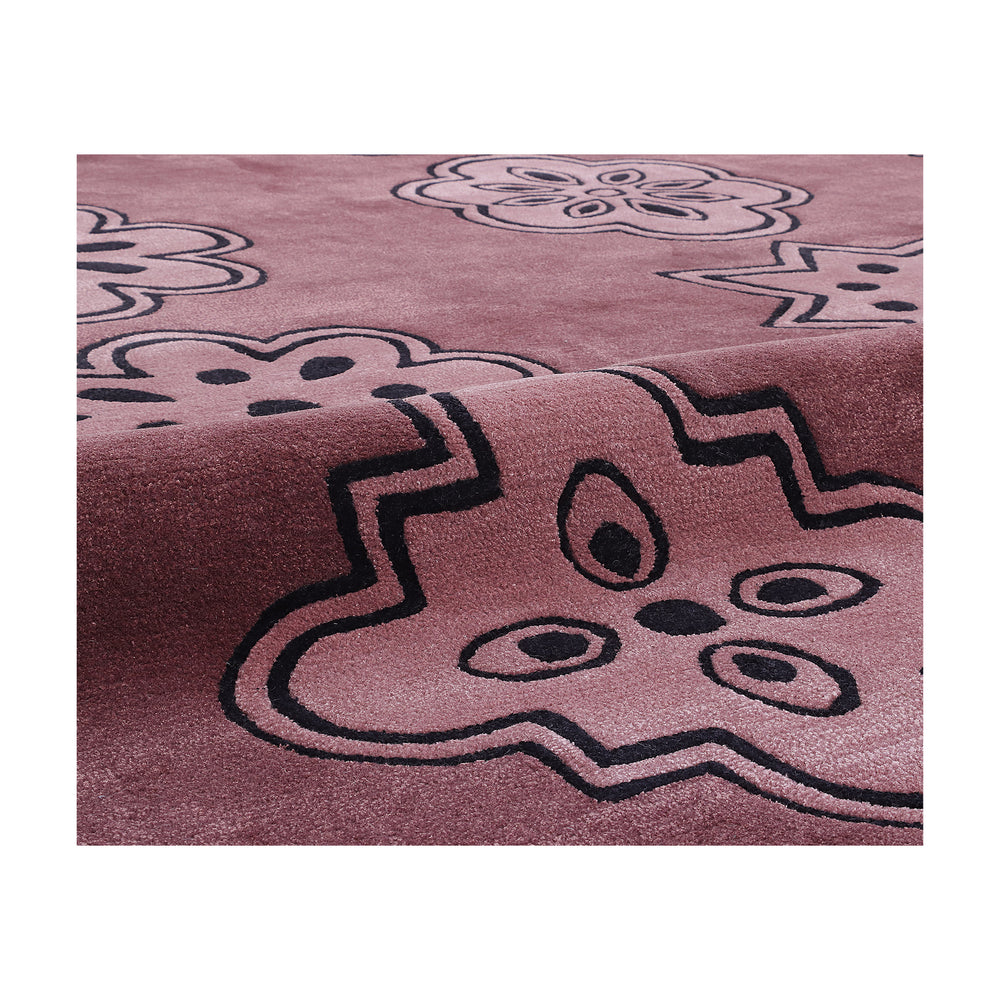 Close-up of the tonal floral medallion motif on the plum ground of the Dotta rug