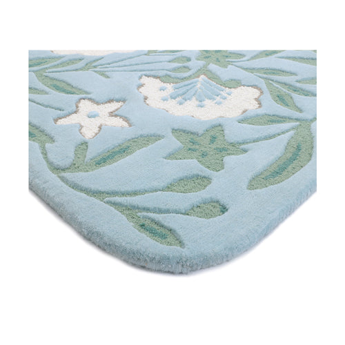 Folded edge of the Garden wool rug showing the binding and botanical pattern