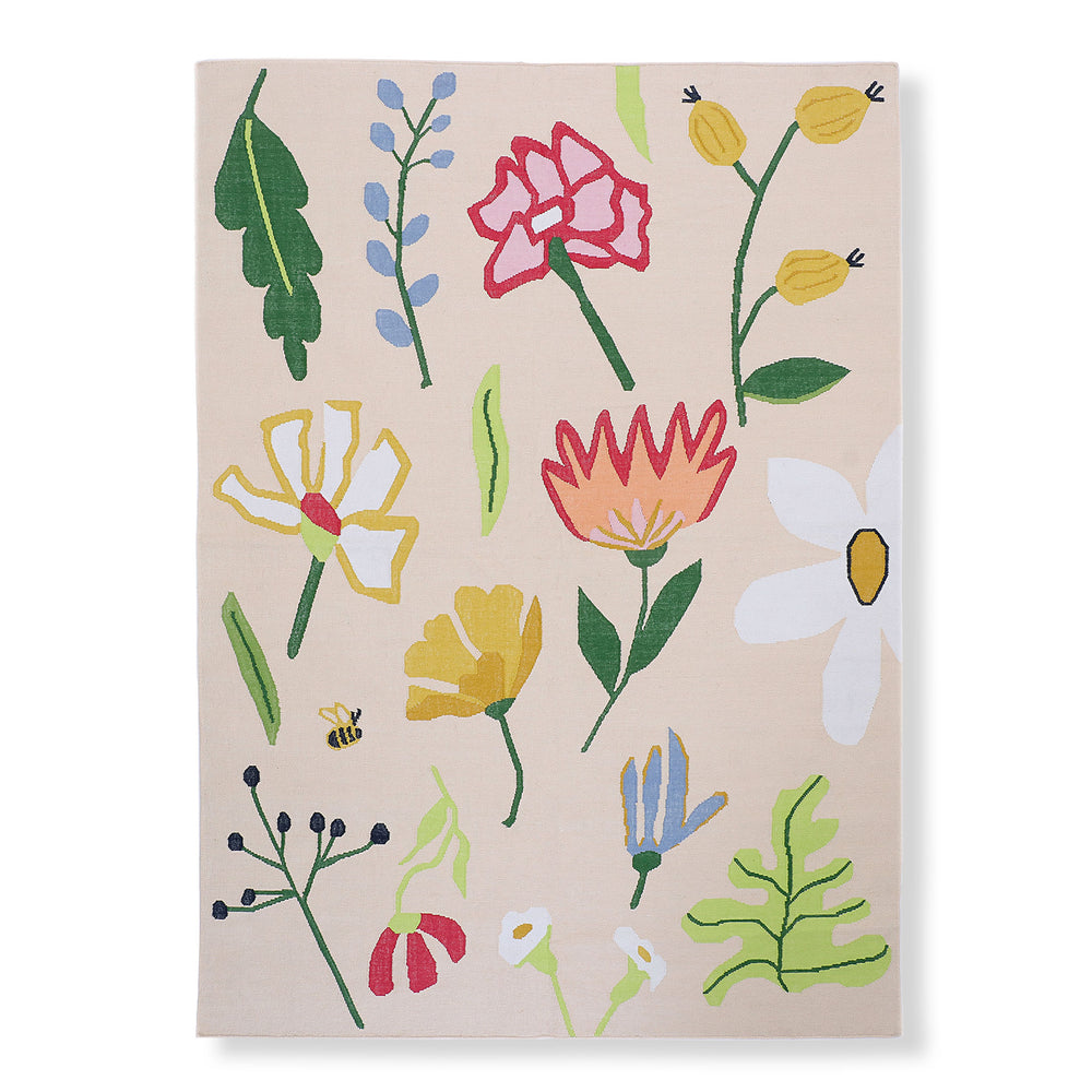 Petaline hand-woven indoor outdoor rug with hand-drawn blooms and a bee on a soft cream ground
