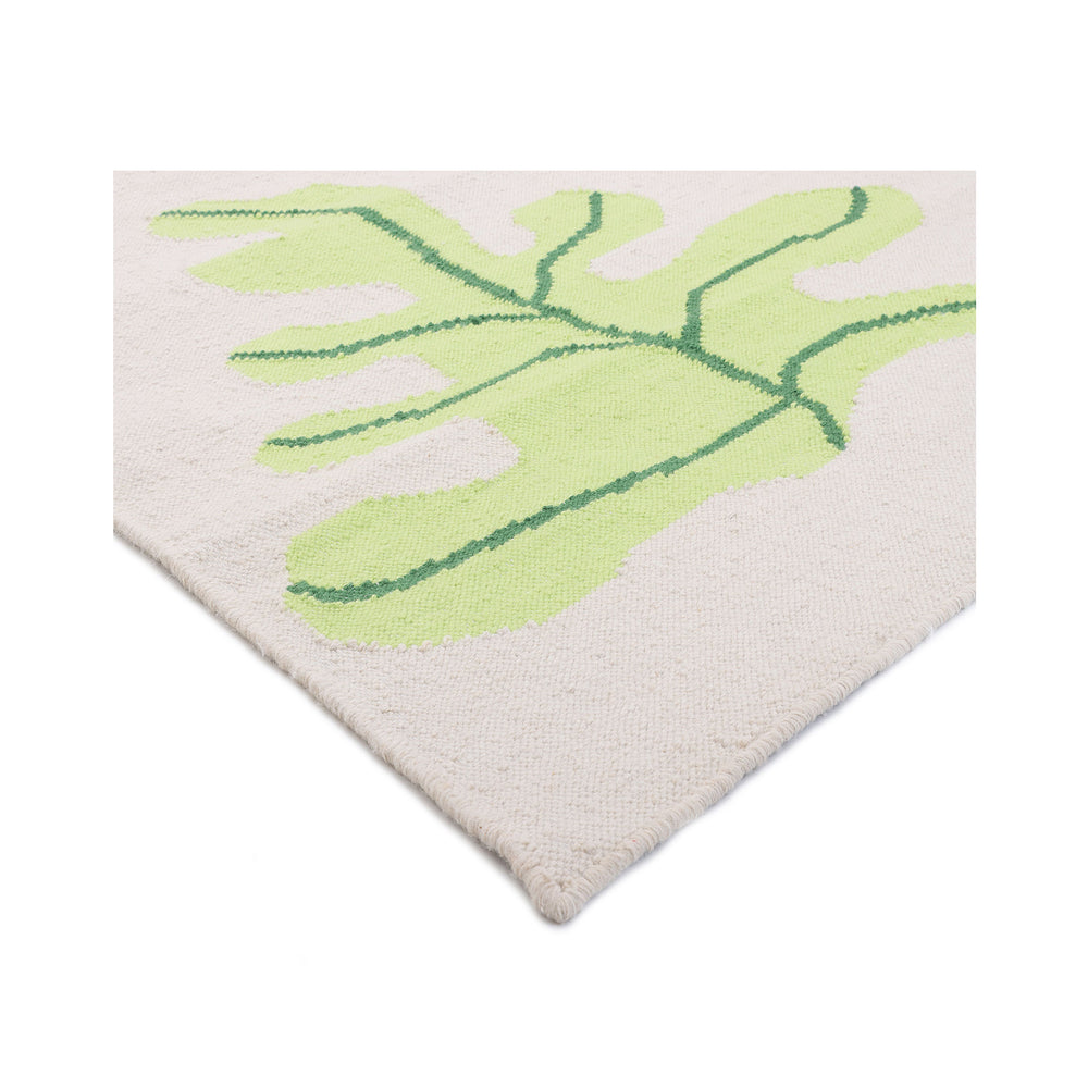 Corner of the Petaline rug folded back to show the flat hand-woven recycled texture